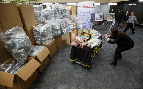 MIKE DEAL / WINNIPEG FREE PRESS
A reporter gets in close to take a photo with her phone before the start of press conference.
Around 1000 lbs of marihuana and related materials were caught in a standard regulatory inspection stop by an RCMP officer on the Trans-Canada Highway in Westhawk, MB on July 22, 2018. According to the RCMP the seizure is the largest marihuana seizure through a traffic stop in Canada since 2015.
The drugs were put on display for the media at D Division Headquarters Friday morning.
180727 - Friday, July 27, 2018.