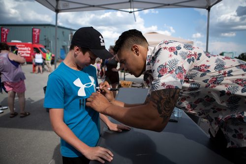 ANDREW RYAN / WINNIPEG FREE PRESS Washington Capitals defence-man Madison Bowey signs Jayden Ward's shirt after he wanted two and a half hours to see the NHL star in his home town with the stately cup on July 28, 2018.