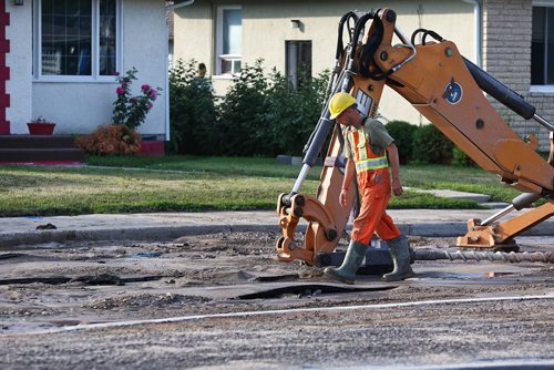 MIKE DEAL / WINNIPEG FREE PRESS
A Winnipeg Water Services crew gets ready to drill holes in the northbound lanes of McPhillips Street between College Avenue and Redwood Avenue Monday morning after a severe water main break buckled the pavement. 
180730 - Monday, July 30, 2018.