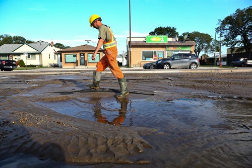 MIKE DEAL / WINNIPEG FREE PRESS
A Winnipeg Water Services crew gets ready to drill holes in the northbound lanes of McPhillips Street between College Avenue and Redwood Avenue Monday morning after a severe water main break buckled the pavement. 
180730 - Monday, July 30, 2018.