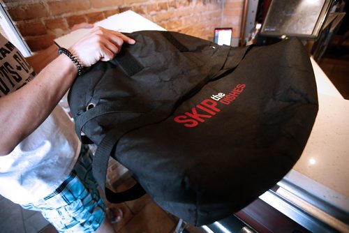 JOHN WOODS / WINNIPEG FREE PRESS
A driver from Skip The Dishes, the food delivery service, picks up some food at local Winnipeg restaurant Monday, July 30, 2018. The service provider is having labour issues.