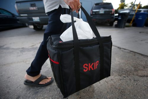 JOHN WOODS / WINNIPEG FREE PRESS
A driver from Skip The Dishes, the food delivery service, picks up some food at local Winnipeg restaurant Monday, July 30, 2018. The service provider is having labour issues.