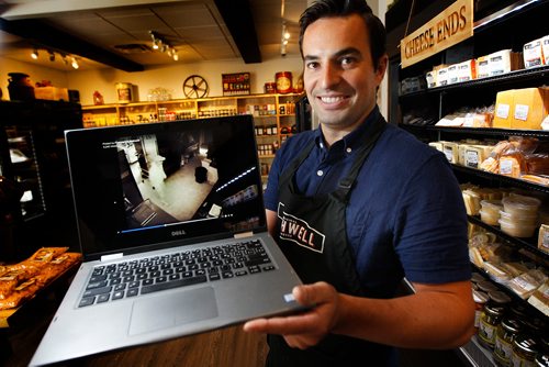 PHIL HOSSACK / WINNIPEG FREE PRESS - Jean-Marc Champagne shows a copy of the security video at his Fromage Bothwell deli on Provencher ave Tuesday. He's offering a year's worth of cheese to anyone who can ID the culprit in the video who broke into the shop last night.  See story. - July 30, 2018