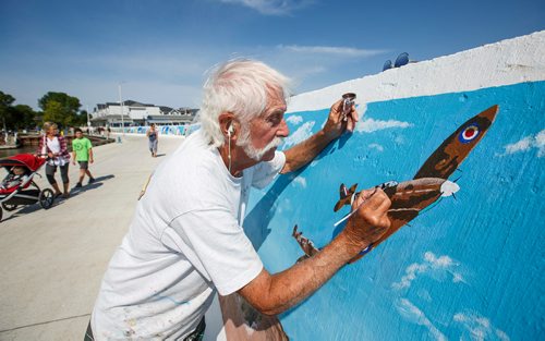 MIKE DEAL / WINNIPEG FREE PRESS
Painter Millard Vance Barteaux retouches one of the murals on the harbour front wall in Gimli Thursday morning.
180802 - Thursday, August 02, 2018.