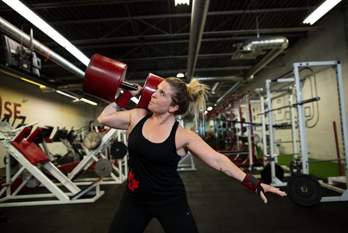 ANDREW RYAN / WINNIPEG FREE PRESS Megan Swidnicki lifts a circus dumbbell at Brickhouse Gym and is set to compete in her first strongman competition at being this weekend held at the same facility. Shot on August 2, 2018.