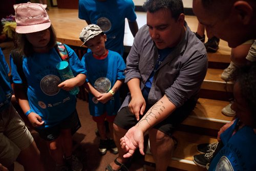 MIKE DEAL / WINNIPEG FREE PRESS
Niigaan Sinclair, TRCM Speakers Bureau Member and Winnipeg Free Press Columnist talks to the kids about his tattoo of the 1817 Peguis-Selkirk Treaty during a celebration at the MB Museum of the anniversary of the signing of Treaty One which took place on August 3rd, 1871.
180803 - Friday, August 03, 2018.