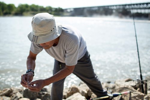 ANDREW RYAN / WINNIPEG FREE PRESS Angler, Romualdo Sison baits his line along the Red River just down stream from the Lockport Dam on August 3, 2018. Judy Robertson, past president of the Wildlife Haven Rehabilitation centre, advocated for monofilament (fishing line) recycling boxes at the Lockport Lock and Dam after seeing the same program in Florida.