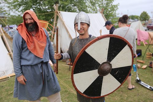 TREVOR HAGAN / WINNIPEG FREE PRESS
Jason Jackson, from Winnipeg, assists Fangshuo Zhang, from Beijing, as he tries on chainmail armour at the Icelandic Festival in Gimli, Sunday, August 5, 2018.