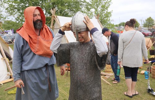 TREVOR HAGAN / WINNIPEG FREE PRESS
Jason Jackson, from Winnipeg, assists Fangshuo Zhang, from Beijing, as he tries on chainmail armour at the Icelandic Festival in Gimli, Sunday, August 5, 2018.