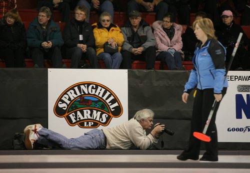 Brandon Sun Neepawa Press editor Jack Gibson reviews his images on his camera as he shoots from ice level at the Scotties Tournament of Hearts on Wednesday afternoon. PLEASE NOTE NEEPAWA PRESS not BANNER (Bruce Bumstead/Brandon Sun)
