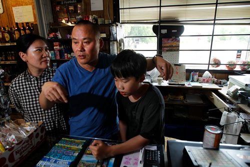 PHIL HOSSACK / WINNIPEG FREE PRESS - Fran Chen his wife Lily and son Michael describe what they saw from the step of their Alosa General store Friday as the Tornado approached the village then veered away suddenly saving the community. From Shanghai Frank and his family had never seen such a storm and went outside to look not knowing to seek shelter in basements.  See story. - August 7, 2018