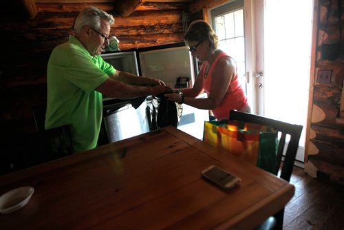 PHIL HOSSACK / WINNIPEG FREE PRESS - Val and Arnold Asham remove ruined meat and other food from the refrigerator at their log cottage which was lifted off its foundation and a sunroom/porch ripped off in Friday's tornado. Looters were chased off the beach shortly after the storm. See story. - August 8, 2018