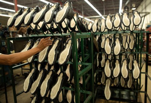 ANDREW RYAN / WINNIPEG FREE PRESS A worker reaches for a partially completed boot on the assembly line of the Canada West Boots manufacturing centre on August 9, 2018. The pleated sole is something which sets the company apart in terms of quality.