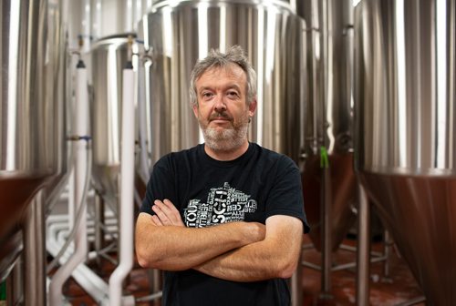ANDREW RYAN / WINNIPEG FREE PRESS Paul Clerkin of Stone Angel poses for a portrait in front of the brewery's fermenters. Clerkin is part of the collective of brewers operating out of the same facility in the belief that strength in numbers will help the brewers' success against international beer conglomerates. Shot on August 10, 2018.