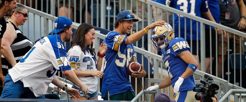 PHIL HOSSACK / WINNIPEG FREE PRESS - Winnipeg Blue Bober #7 Weston Dressler gets up close and personal handing out the game ball to fans after scoring the Bombers first TD Friday night at Investor's Group Stadium in Winnipeg. See story. - August 10, 2018