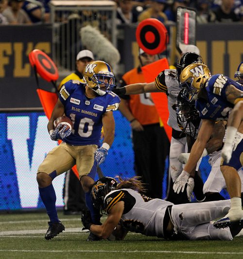 PHIL HOSSACK / WINNIPEG FREE PRESS - Winnipeg Blue Bomber #10 Nic Demski looks for running room as  Hamilton's Ti-Cat #43 Lucas Wacha latches onto his ankle in the 2nd half Friday night at Investor's Group Stadium in Winnipeg. See story. - August 10, 2018