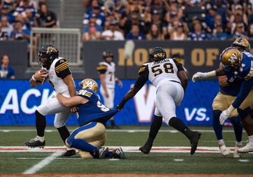 ANDREW RYAN / WINNIPEG FREE PRESS Hamilton Tiger-Cats' quarterback Jeremiah Masoli (8) carries the ball while being dragged down by Jake Thomas (95) in game action on August 10, 2018.