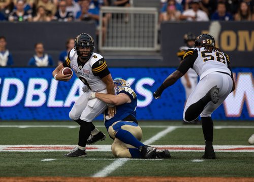 ANDREW RYAN / WINNIPEG FREE PRESS Hamilton Tiger-Cats' quarterback Jeremiah Masoli (8) carries the ball while being dragged down by Jake Thomas (95) in game action on August 10, 2018.