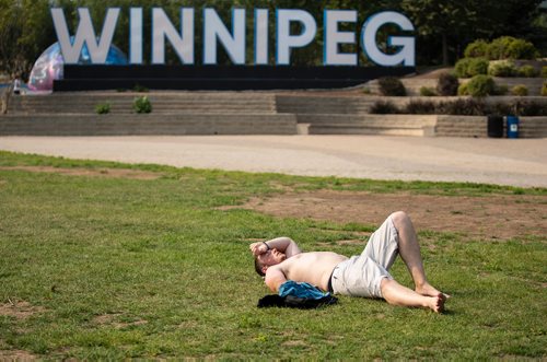ANDREW RYAN / WINNIPEG FREE PRESS Thomas Gregson lays sweaty in the sun after throwing around a frisbee in The Forks park on August 11, 2018.