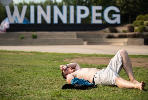ANDREW RYAN / WINNIPEG FREE PRESS Thomas Gregson lays sweaty in the sun after throwing around a frisbee in The Forks park on August 11, 2018.