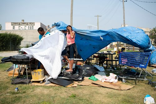 ANDREW RYAN / WINNIPEG FREE PRESS Kyle Bighetty and Debra Paul put together their makeshift shelter to shade themselves from the searing temperatures that reached Winnipeg Saturday August 11, 2018.
