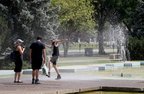 TREVOR HAGAN / WINNIPEG FREE PRESS
Adara Moreau and Bret Parenteau laugh as the wind shifts, sending spray onto Liam Baker, who is visiting from Hamilton, at the fountain on Memorial Boulevard, Sunday, August 12, 2018.