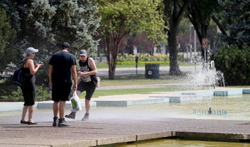 TREVOR HAGAN / WINNIPEG FREE PRESS
Adara Moreau and Bret Parenteau laugh as the wind shifts, sending spray onto Liam Baker, who is visiting from Hamilton, at the fountain on Memorial Boulevard, Sunday, August 12, 2018.