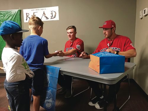 Canstar Community News (From left) Winnipeg Goldeyes players P.J. Browne and Edwin Carl were at Henderson Library (1-1050 Henderson Hwy.) on Aug. 7. The pair read "Casey Back at Bat" by Dan Gutman to a crowd of nearly two dozen kids and their parents before signing baseballs and bookmarks. (SHELDON BIRNIE/CANSTAR/THE HERALD)