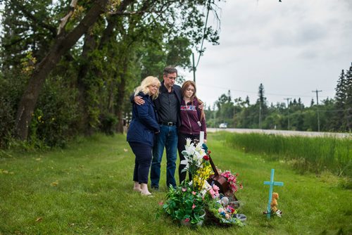 MIKAELA MACKENZIE / WINNIPEG FREE PRESS
Brenda (left), John, and Hannah Harris stand by the makeshift memorial at Donald road and highway nine, where Ben Harris was killed in a hit-and-run, in the R.M. of St. Andrews on Monday, Aug. 13, 2018. 
Winnipeg Free Press 2018.