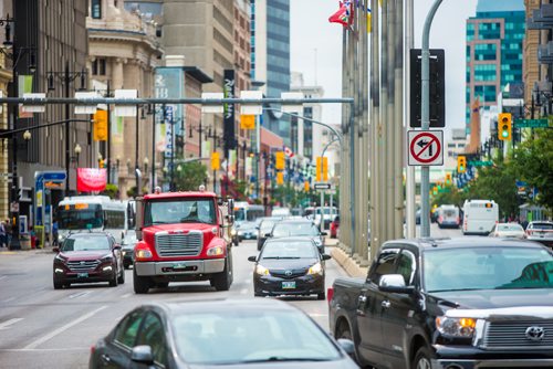 MIKAELA MACKENZIE / WINNIPEG FREE PRESS
Trucks pass through Portage and Main in Winnipeg on Monday, Aug. 13, 2018. 
Winnipeg Free Press 2018.