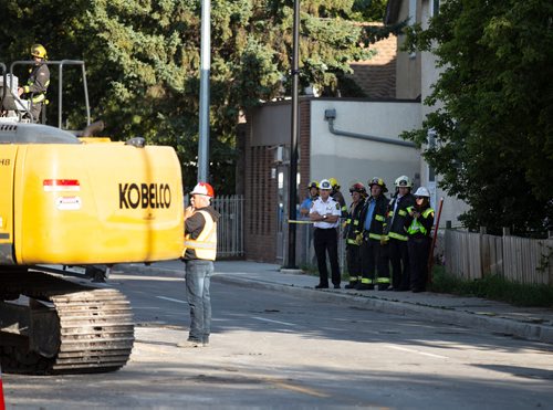 ANDREW RYAN / WINNIPEG FREE PRESS Emergency workers watch as a demolition crew tears down the rooming house that caught fire overnight on Selkirk Ave. on August 15, 2018.