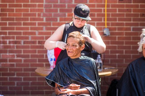 MIKAELA MACKENZIE / WINNIPEG FREE PRESS
Debra Paul gets her hair cut by Sydney Brosch at a pickup street hockey game and barbecue hosted by the Main Street Project on Martha Street in Winnipeg on Wednesday, Aug. 15, 2018. 
Winnipeg Free Press 2018.