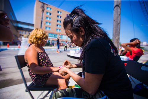 MIKAELA MACKENZIE / WINNIPEG FREE PRESS
Page Longbottom gets her nails done by Jane Warkola at a pickup street hockey game and barbecue hosted by the Main Street Project on Martha Street in Winnipeg on Wednesday, Aug. 15, 2018. 
Winnipeg Free Press 2018.