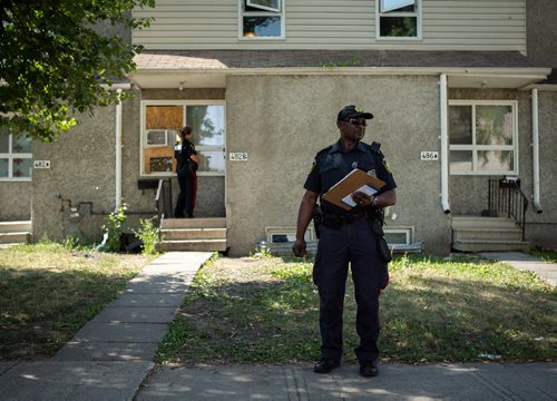 ANDREW RYAN / WINNIPEG FREE PRESS Constable Missen Odidison stands by while patrol sergeant Shaunna Neufeld speaks to residents in the William Whyte neighbourhood about the Make the Right Call campaign, part of the Winnipeg Police's attempt to increase their positive presence in the city's north end neighbourhood on Manitoba Ave. on August 15, 2018.