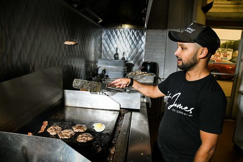 Mike Sudoma / Winnipeg Free Press
Samjay Sewpaul of St James Burger flips a patty while grilling a few local favourites Thursday morning. August 16, 2018. St. James Burger & Chip Co.