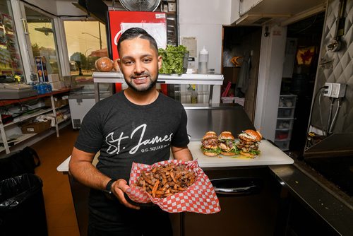 Mike Sudoma / Winnipeg Free Press
Sanjay Sewpaul proudly showing off his creations alongside a big order of fries at St James Burger Thursday morning. August 16, 2018. St. James Burger & Chip Co.