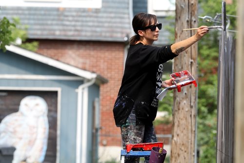 TREVOR HAGAN / WINNIPEG FREE PRESS
Kal Barteski works on another large mural in the alley between Ethelbert Street and Canora Street, Friday, August 17, 2018.