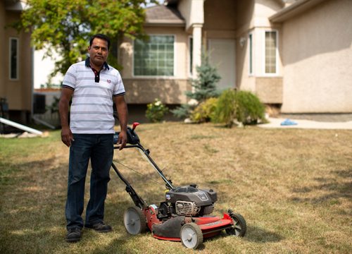 ANDREW RYAN / WINNIPEG FREE PRESS Jacky Maan, owner of Regal Grass, poses for a portrait on one of his customer's overly dried out lawns in Lindenwood on August 20, 2018. The dry summer weather has taken a toll on landscaping and gardening businesses.