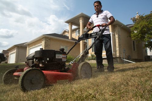 ANDREW RYAN / WINNIPEG FREE PRESS Jacky Maan, owner of Regal Grass, mows one of his customer's overly dried out lawns in Lindenwood on August 20, 2018. The dry summer weather has taken a toll on landscaping and gardening businesses.