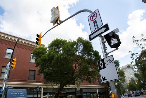 ANDREW RYAN / WINNIPEG FREE PRESS Newly installed signage and traffic lights regulating traffic to protect bicyclists along McDermott Avenue in the Exchange district on August 21, 2018.