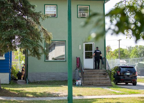 ANDREW RYAN / WINNIPEG FREE PRESS An officer walks into the home where nearby residents heard gun shots along McGregor Street and Cathedral Avenue on August 23, 2018.