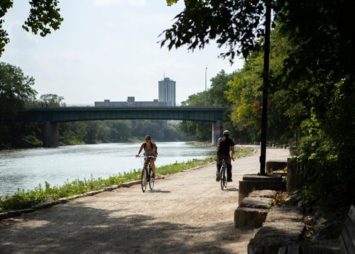ANDREW RYAN / WINNIPEG FREE PRESS A man and a woman ride their bicycles past each other along the Assiniboine River near Bonnycastle Park on August 23, 2018. river walk