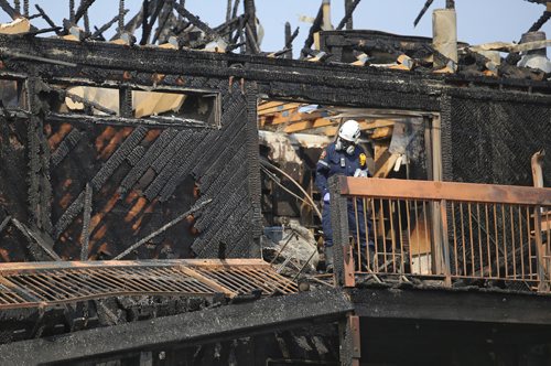 TREVOR HAGAN / WINNIPEG FREE PRESS
An investigator from the fire department takes photos on the third floor at the scene of a fire at the corner of Vermillion Road and Grover Hills Lane, Sunday, August 26, 2018.