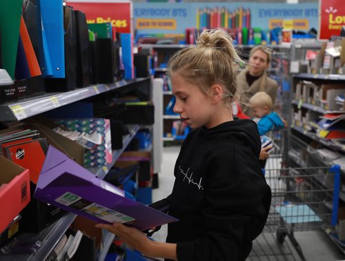 RUTH BONNEVILLE / WINNIPEG FREE PRESS

Standup photo 
Families take advantage of the cool weather to do their back-to-school shopping with their kids at Walmart on Grant on Monday afternoon. 

Alexandra Scholl (11yrs) looks for duo-tang report folders for her upcoming year in grade 7 as her little brothers, Johnny (8yrs), David (1yr) and mom, Tatjana Scholl, look on while at Walmart Monday. 

August 27/18
