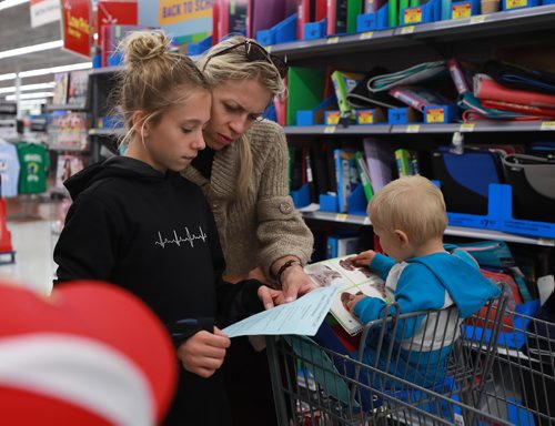 RUTH BONNEVILLE / WINNIPEG FREE PRESS

Standup photo 
Families take advantage of the cool weather to do their back-to-school shopping with their kids at Walmart on Grant on Monday afternoon. 

Alexandra Scholl (11yrs) looks over her supply list with her mom,  Tatjana Scholl,  for her upcoming year in grade 7 as her little brothers, David (1yr) and Johnny (8yrs)  look on while at Walmart Monday. 

August 27/18
