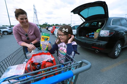 RUTH BONNEVILLE / WINNIPEG FREE PRESS

Standup photo 
Families take advantage of the cool weather to do their back-to-school shopping with their kids at Walmart on Grant on Monday afternoon. 

Sofia Marinelli (6yrs) can't hold back her excitement as she digs into her bag of new school supplies while loading them into the car with her mom, Jessica Marinelli, at Walmart Monday. 



August 27/18
