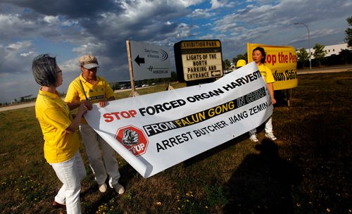 PHIL HOSSACK / WINNIPEG FREE PRESS -  Falun Dafa arrange their protest banners at the entrance to the Chinese Northern Lights exhibition Friday. See Carol Sanders story.  - August 31, 2018