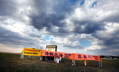 PHIL HOSSACK / WINNIPEG FREE PRESS -  Falun Dafa arrange their protest banners at the entrance to the Chinese Northern Lights exhibition Friday. See Carol Sanders story.  - August 31, 2018