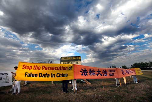 PHIL HOSSACK / WINNIPEG FREE PRESS -  Falun Dafa arrange their protest banners at the entrance to the Chinese Northern Lights exhibition Friday. See Carol Sanders story.  - August 31, 2018