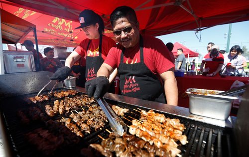 JOHN WOODS / WINNIPEG FREE PRESS
Ria Cacao, left, and Julinn Garcia, cooks at Hot Rod's Filipino Grill, cook  some pork intestine delicacies at the third annual Food Trip, the Filipino food festival, at Tyndall Park, Sunday, September 2, 2018.